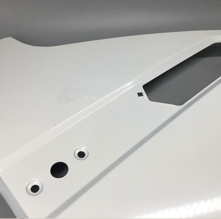 White front fender outer panel close-up with round mounting holes