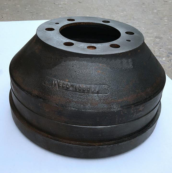 Brake drum assembly with rusted black body and silver top plate, bolt holes visible