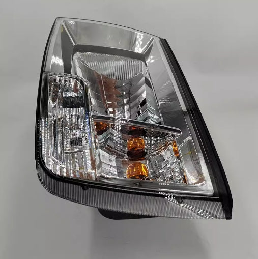 Close-up of front headlight with clear reflector housing and amber indicator bulbs