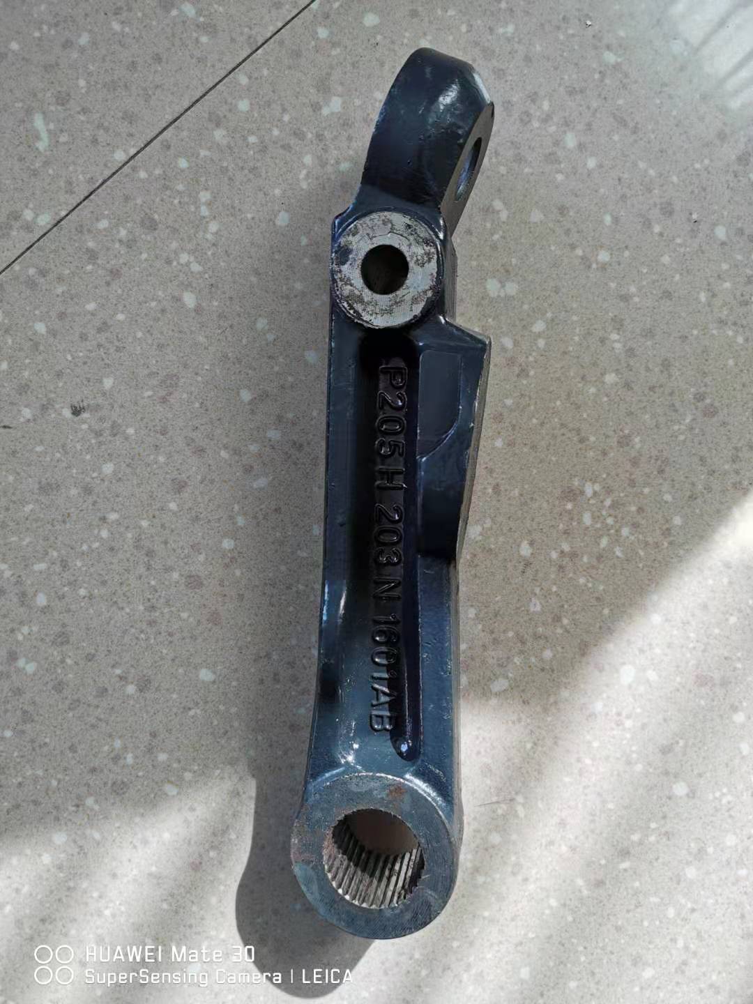 Swing arm with stamped code and circular bushing hole, blue-black steel arm