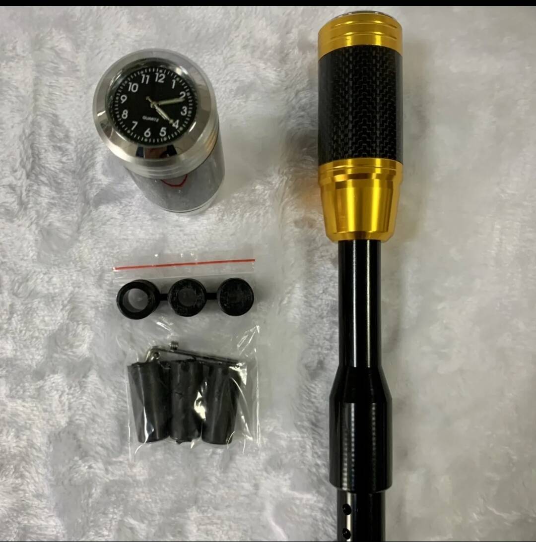 Gold shift knob lengthener with clock gauge, carbon-fiber grip, and rubber mounting caps