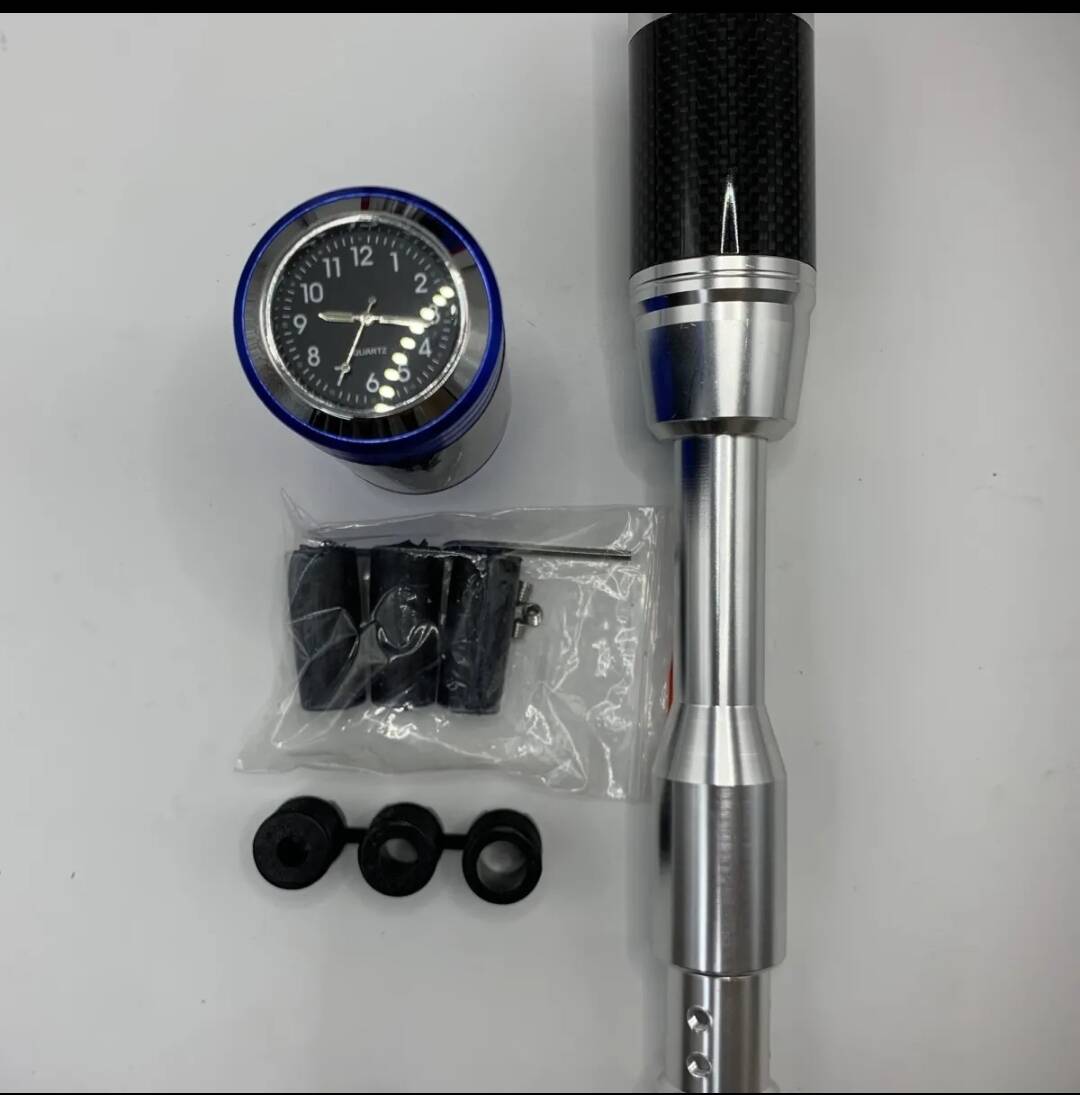 Silver shift knob lengthener with clock gauge, carbon-fiber top, and mounting rubber caps