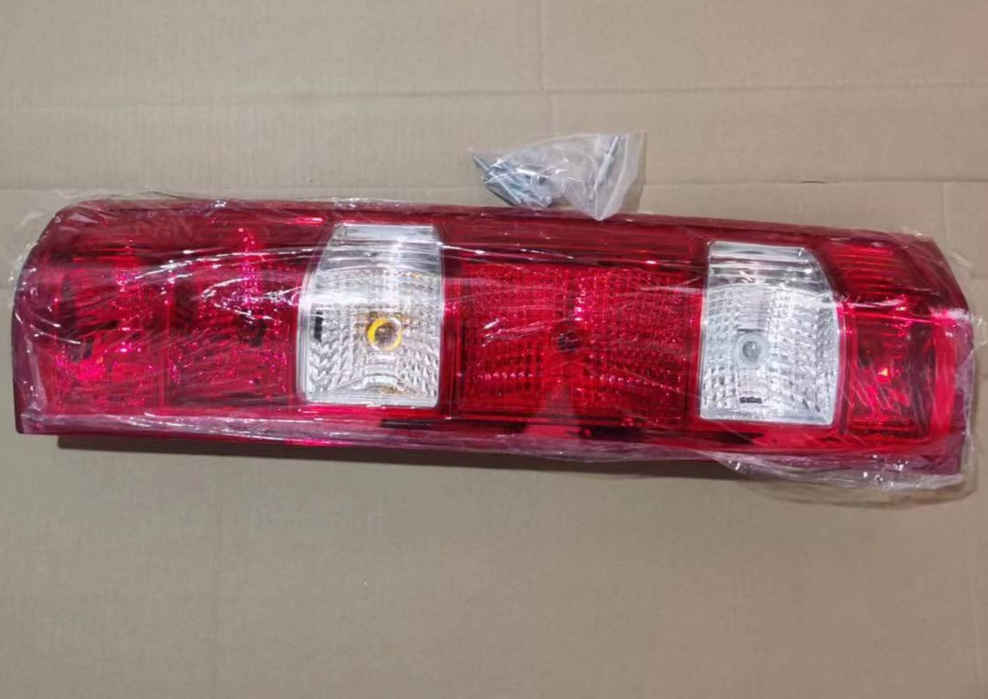Red tail lamp with two clear rectangular lenses and amber bulb, wrapped for shipping by SUONAMA