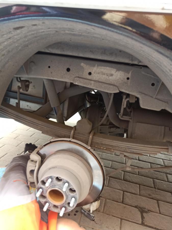 Rear air suspension components under chassis near wheel hub, showing air spring and brackets