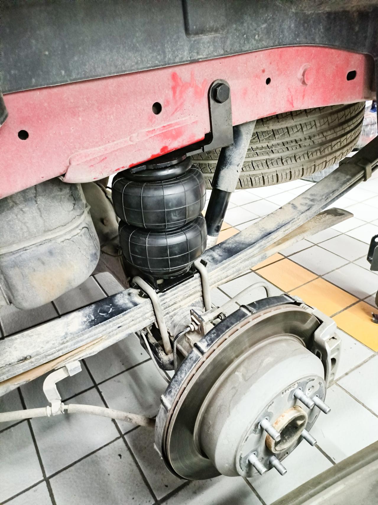 Rear air suspension installed under vehicle: air bellows, brackets, and mounting hardware