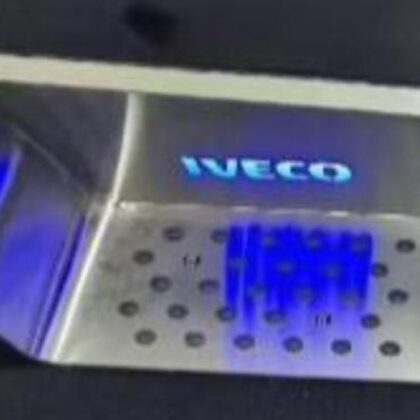 Stainless steel step board close-up with perforated tread and IVECO logo, blue LED